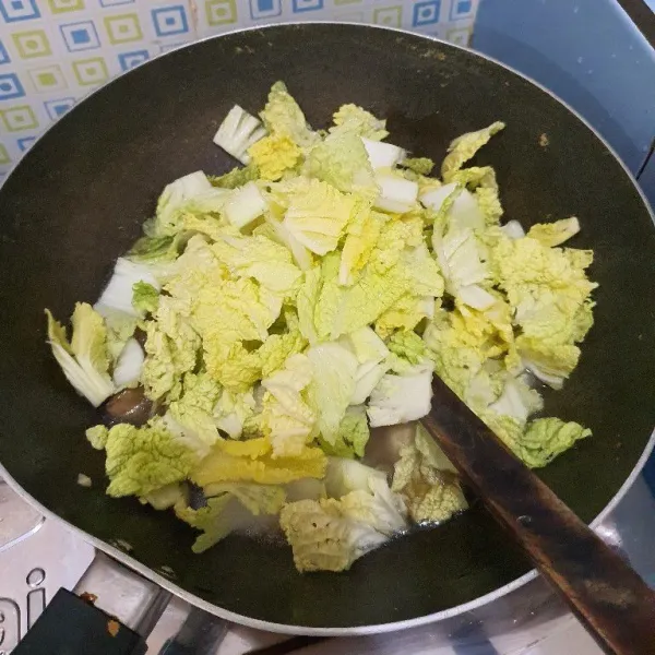 Masukkan sawi dan masak hingga layu.