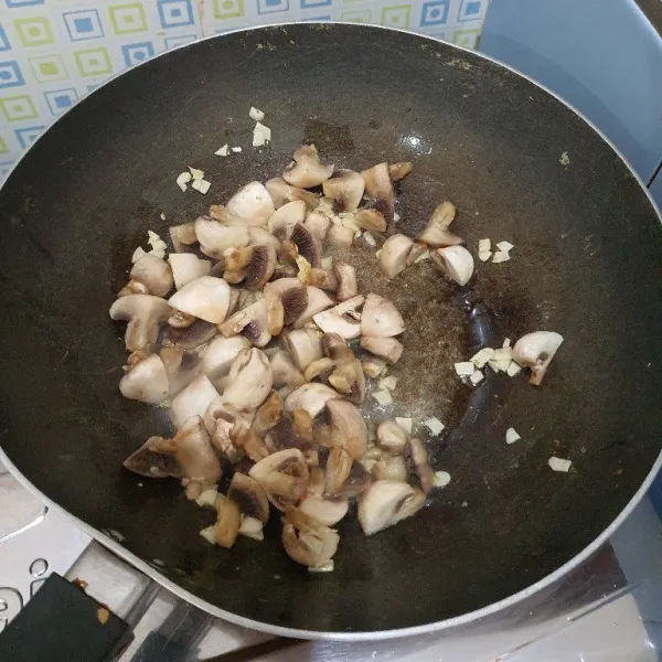 Masukkan jamur aduk rata, tambahkan saus tiram, garam, kaldu jamur, gula pasir, dan lada. Masak hingga jamur sedikit layu.