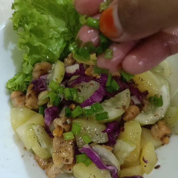 Siapkan mangkuk saji, lalu beri daun selada dan tuang salad secukupnya. Kemudian tambahkan irisan daun bawang dan potongan telur, lalu siap disajikan.