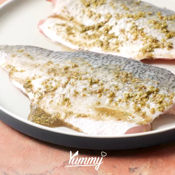 Siapkan ikan Barramundi fillet, oleskan dengan campuran bumbu.