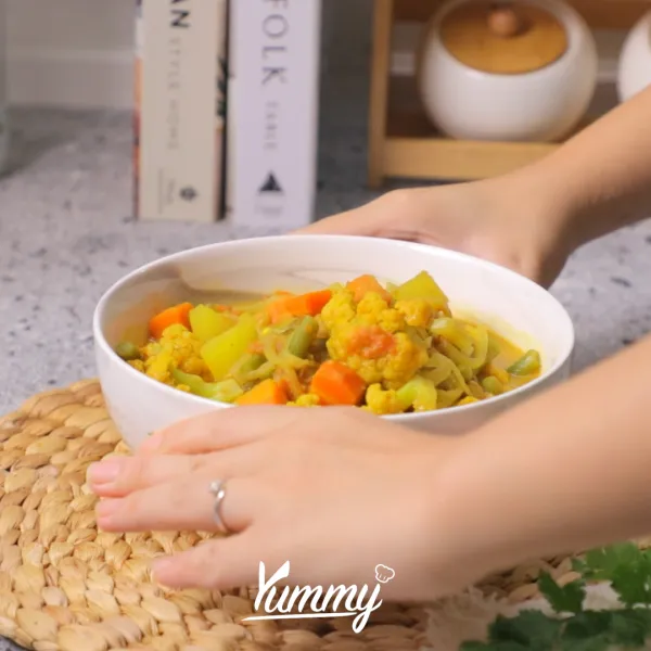 Setelah mendidih, sajikan Vegetable Curry bersama dengan topping yogurt dan taburan daun ketumbar.