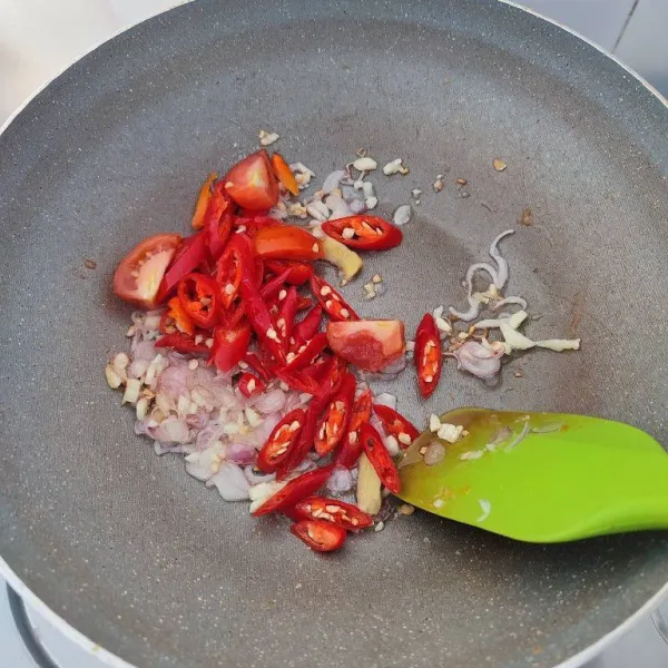 Masukkan irisan cabe merah besar, cabe rawit dan tomat merah, lalu tumis hingga layu.