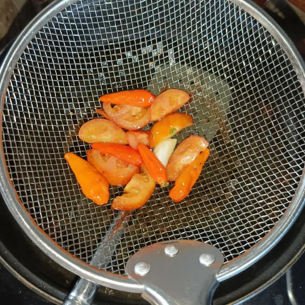 Goreng cabai merah, tomat merah dan bawang putih sampai layu, angkat dan tiriskan sebentar.