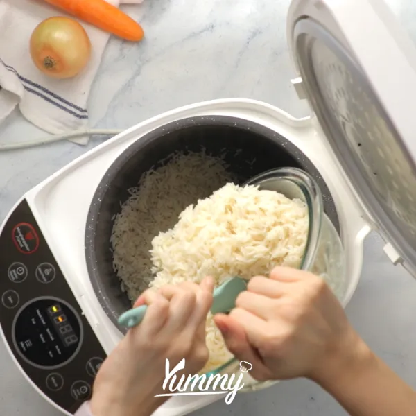 Siapkan rice cooker, masukkan bumbu tumisan dan beras ke dalamnya.