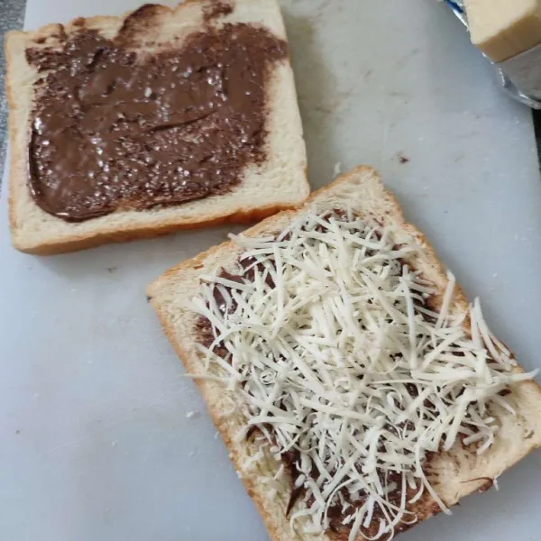 Kemudian beri keju parut diatas permukaan roti yang telah di oles dengan nutella.