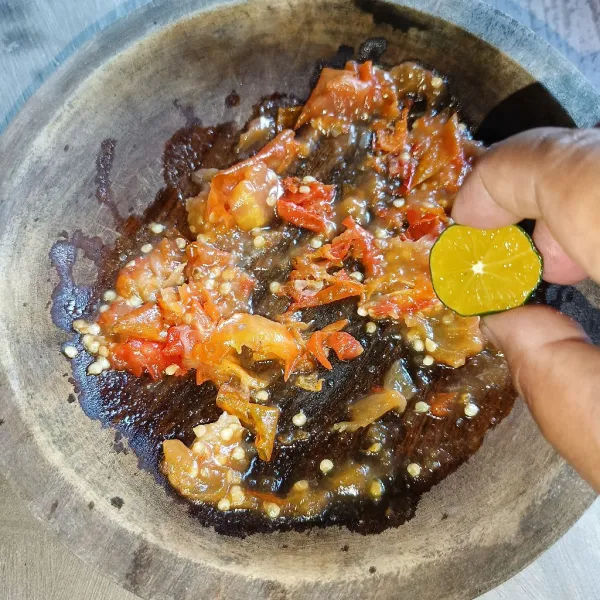 Beri perasan jeruk dan koreksi rasanya. Penyet ayam dan terong di atas sambal sebelum disajikan.