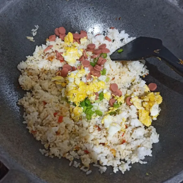 Masukkan telur orek, sosis, dan daun pre.