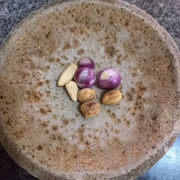 Haluskan bawang merah, bawang putih dan kemiri sangrai.