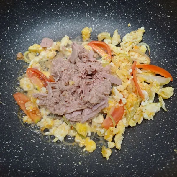 Masukkan ikan tuna dan tomat merah, tumis sebentar. Bumbui merica bubuk, kaldu jamur dan gula pasir. Aduk rata sambil koreksi rasa sesuai selera.