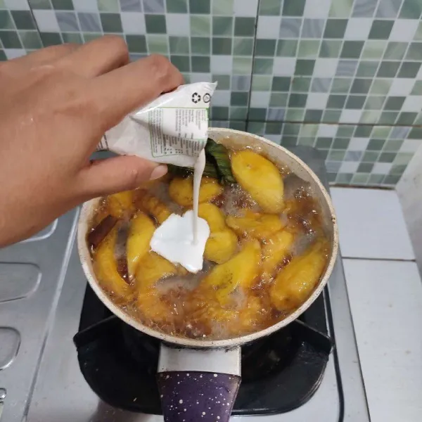 Masak hingga mendidih dan pisang ¾ matang. Setelah itu masukkan santan, aduk rata.