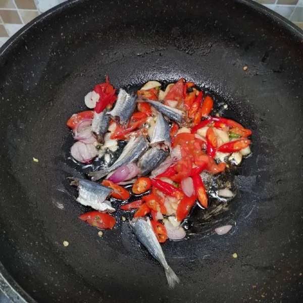 Panaskan wajan, tumis bumbu iris dan ikan asin klotok, masak sampai bumbu layu dan harum.
