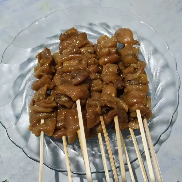 Potong kulit ayam lalu tusuk dengan tusukan sate.