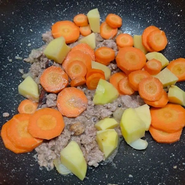 Masukkan wortel dan kentang. Tumis sebentar, kemudian tuang semua sisa air. Masak sampai mendidih.