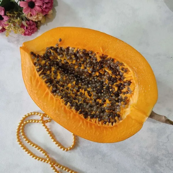 Siapkan buah pepaya lalu kupas dan buang bijinya.