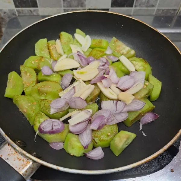 Masukkan irisan bawang merah dan bawang putih, tumis sampai layu lalu angkat dan sisihkan.