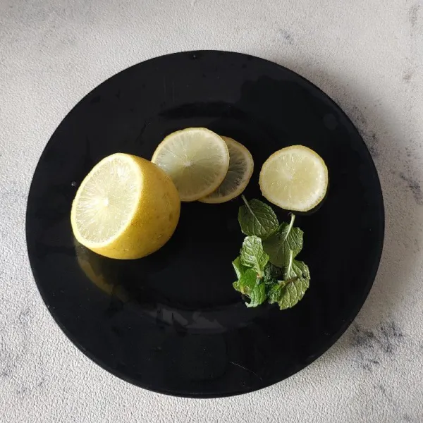 Siapkan buah lemon dan iris tipis, cuci bersih juga daun mint.