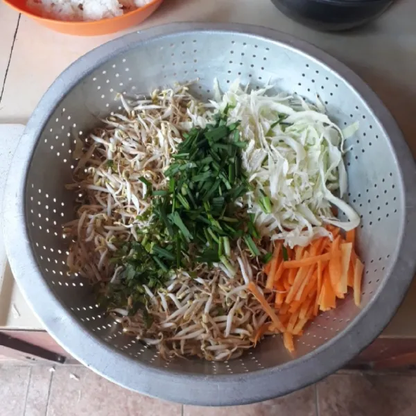 Iris tipis kol dan seledri, potong korek api tipis wortel dan iris 1 cm daun bawang. Campur semua sayuran, cuci bersih dan tiriskan.