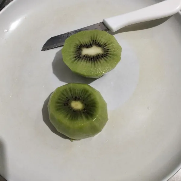 Kupas dan cuci buah kiwi.