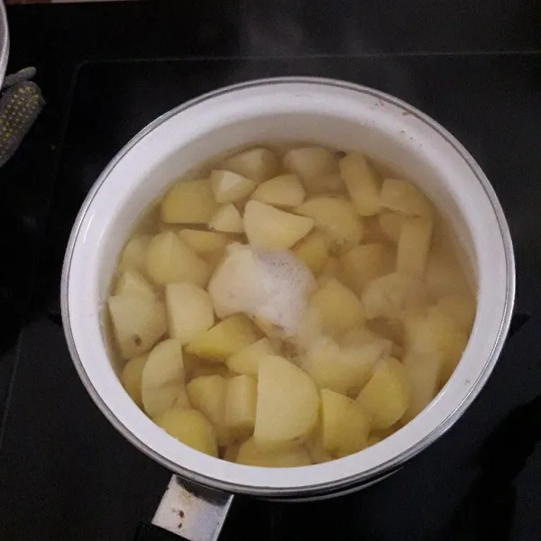 Kupas kentang dan potong kecil-kecil. Didihkan air, lalu rebus kentang sampai empuk. Kemudian tiriskan.