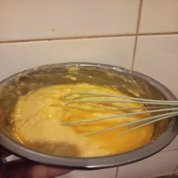Tambahkan mentega cair, aduk hingga rata. Tuang ke dalam loyang 20x10 cm yg sudah di alasi kertas roti. Ratakan, taburi keju parut.