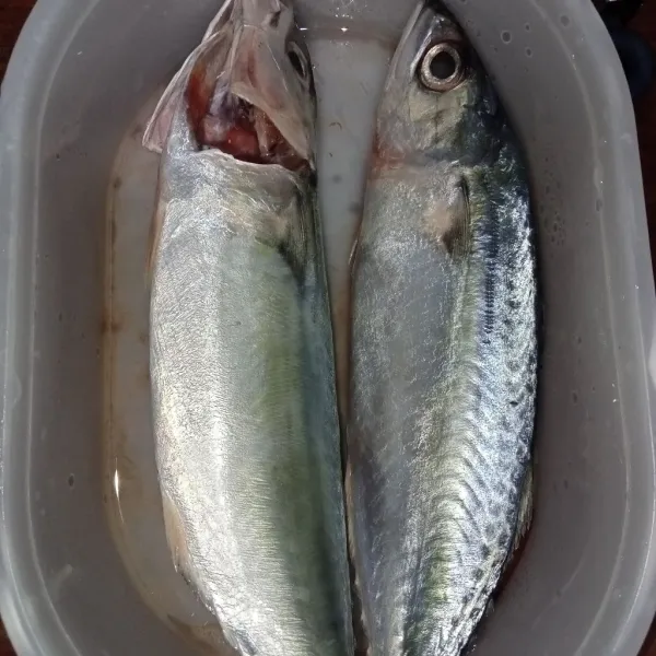 Buang insang ikan, kemudian cuci bersih ikan.