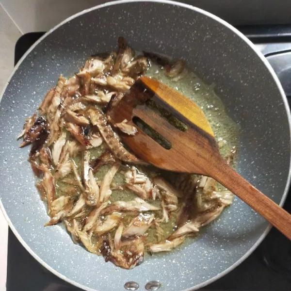 Panaskan minyak, kemudian goreng ikan pindang tongkol hingga kuning kecoklatan.