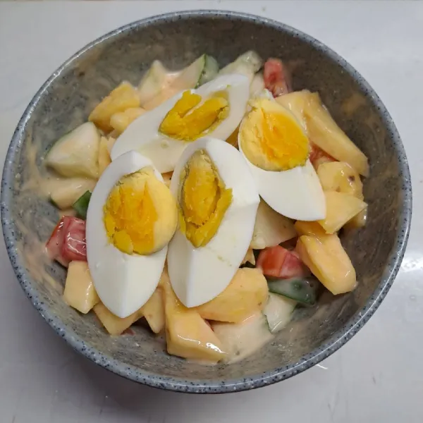 Belah telur rebus jadi empat bagian, sajikan.
