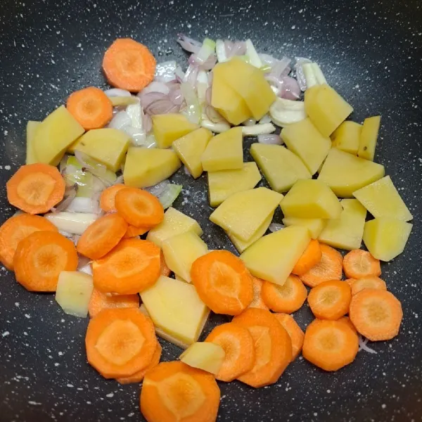 Masukkan wortel dan kentang, tumis sampai ½ layu.