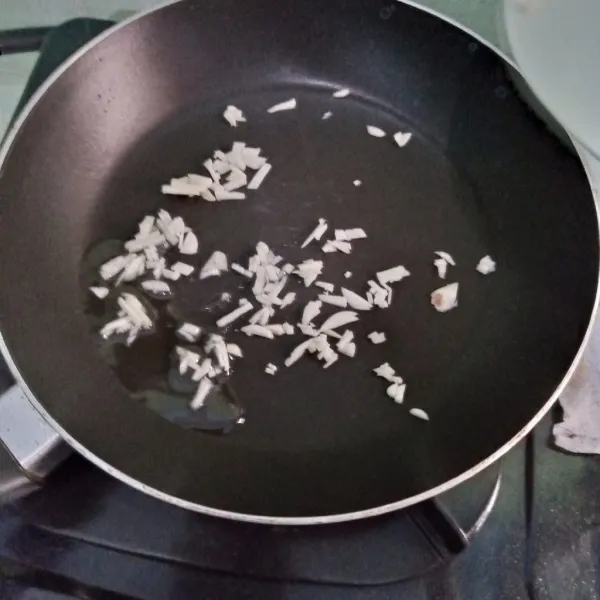 Tumis bawang putih hingga harum.