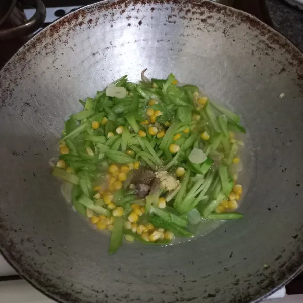 Tambahkan air, masukkan pipilan jagung manis, garam, kaldu jamur, merica bubuk dan gula pasir.