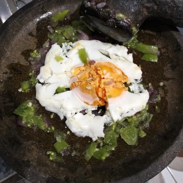 Masukkan telur ke dalam cobek. Geprek.