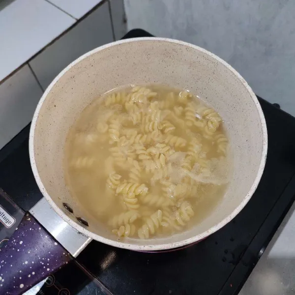 Rebus pasta fusilli dengan air, garam serta minyak goreng hingga aldente, lalu tiriskan.