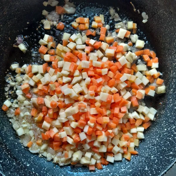 Masukkan potongan wortel dan ubi, aduk rata. Tumis hingga layu.