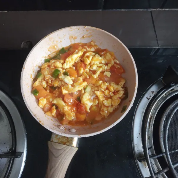 Masukkan telur lalu tambahkan saus tomat, sambal dan air.