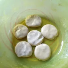 Celupkan bulatan adonan kedalam minyak sambil sedikit dipipihkan. Tata diloyang yang dioles sedikit minyak. Tutup loyang dan diamkan 30 - 60 menit agar lebih elastis.