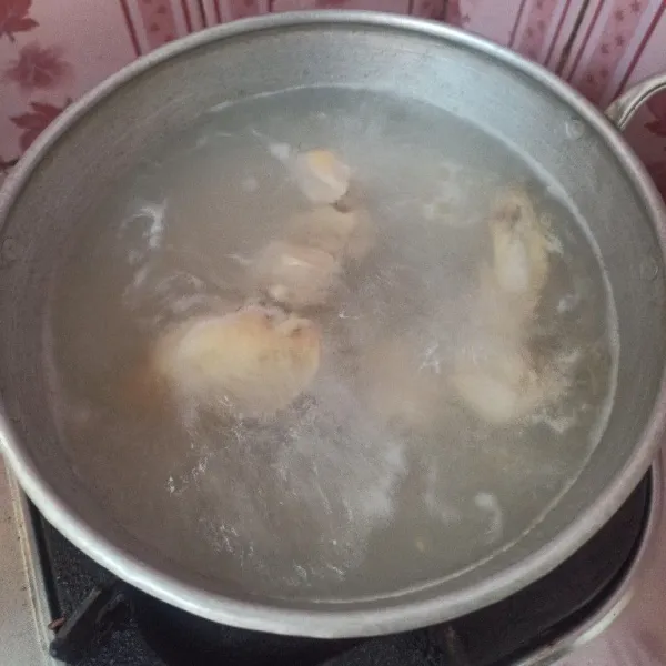 Rebus ayam hingga setengah matang, air rebusan pertama dibuang, setelah itu tambahkan 800ml air rebus ayam hingga matang.