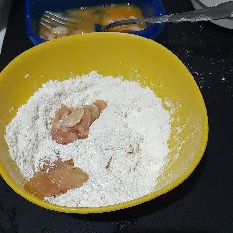 Balur potongan ayam ke dalam tepung kering hingga rata, kemudian goreng hingga matang.