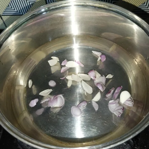 Rebus air serta irisan bawang merah dan bawang putih.
