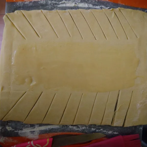 Siapkan kulit pastry, pipihkan, dan potong serong di sisi kanan dan kiri.