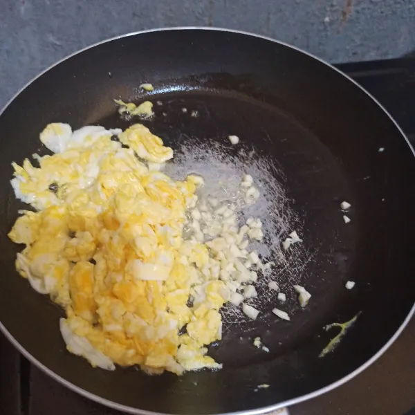 Sisihkan telur, lalu tumis bawang putih cincang.