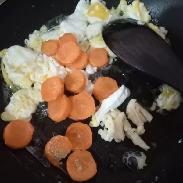 Masukkan bawang putih dan wortel, tumis sebentar.
