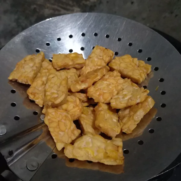 Potong-potong tempe dan goreng sampai kecoklatan.