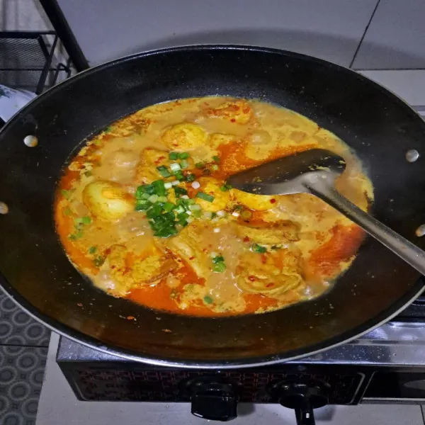 Masukan air sedikit demi sedikit, lalu masukan tahu dan telur yang sudah di goreng. Tambahkan garam, gula pasir dan kaldu bubuk. Masukan santan instan, daun bawang aduk-aduk agar santan tidak pecah. Tes rasa, angkat lalu sajikan.