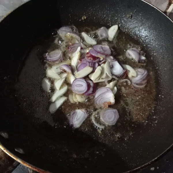 Lalu tumis bawang merah dan bawang putih dengan minyak sisa menggoreng ikan tadi sampai matang.
