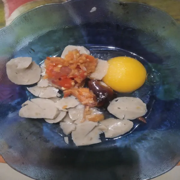Campur telur, bakso bumbu ulek, dan seasoning dalam satu wadah.