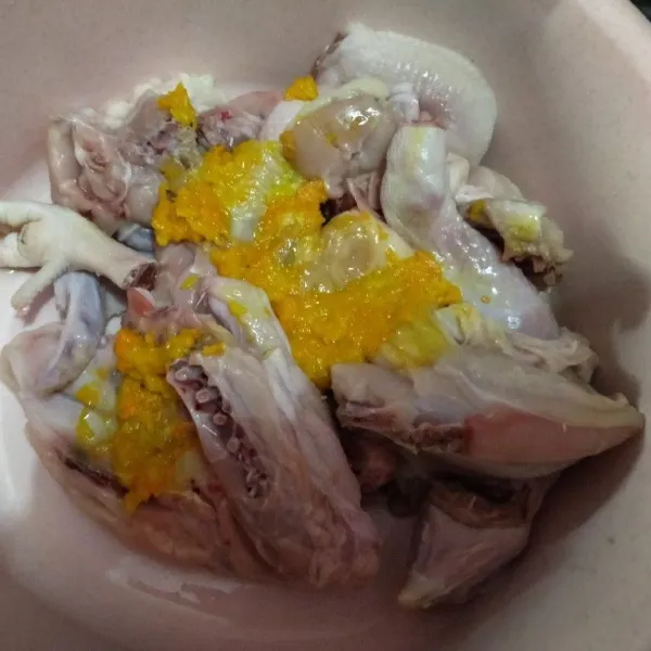Haluskan bawang putih, kunyit, jahe dan garam. Lalu, lumuri ayam dengan bumbu tersebut.
