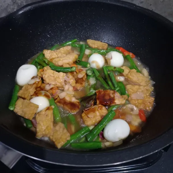 Masukkan tempe, telur puyuh, kacang panjang, dan air.