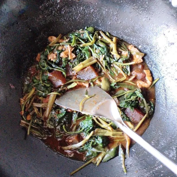 Setelah bumbu mulai harum, tambahkan batang kangkung dan tumis sebentar, masukkan daging beserta air kaldunya. Tuang kecap manis, masak sampai batang layu dan air mulai menyusut. Lalu masukkan daun kangkung, aduk merata, lalu koreksi rasa dan angkat.