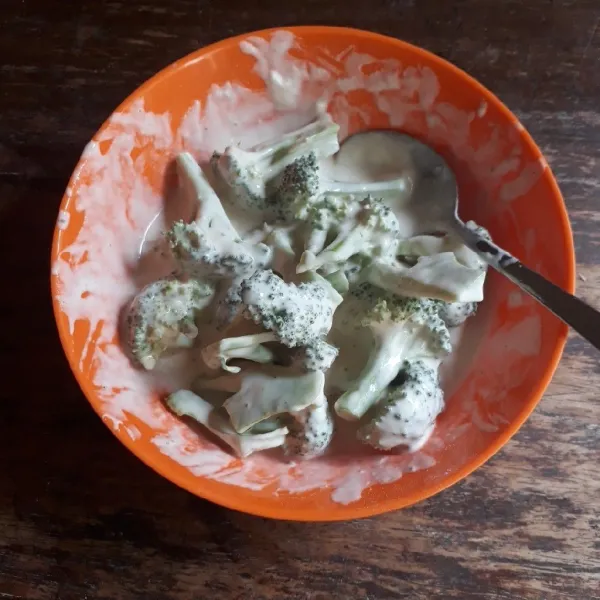 Masukkan brokoli ke adonan tepung, aduk rata.