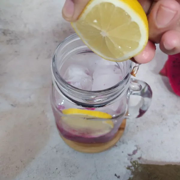 Masukkan es batu, symple syrup dan air lemon. Beri 1 iris lemon.